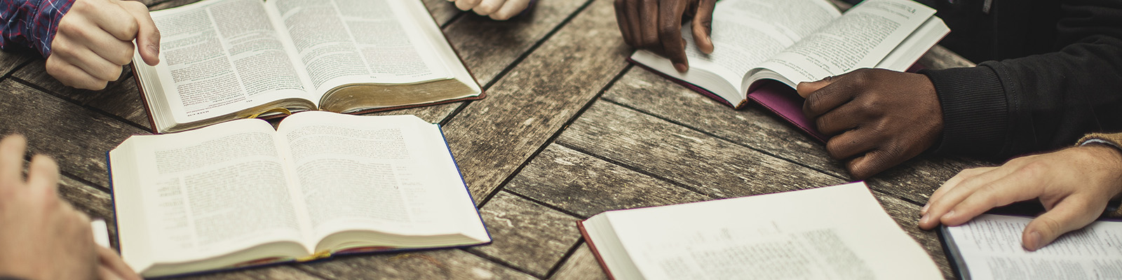 A group seated at a table with Bibles open for study